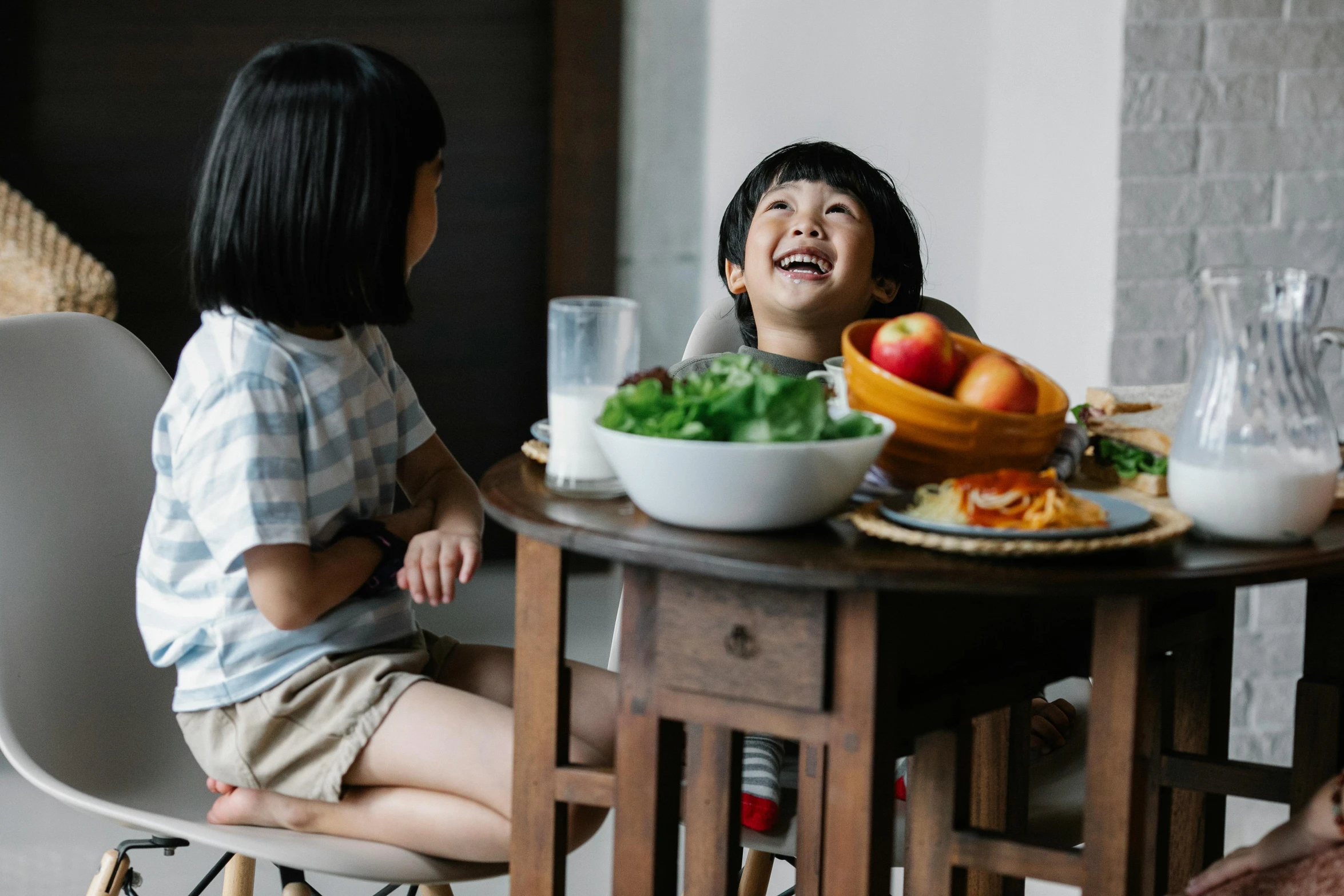 a couple of kids that are sitting at a table, pexels contest winner, asian female, giggling, ingredients on the table, head to waist