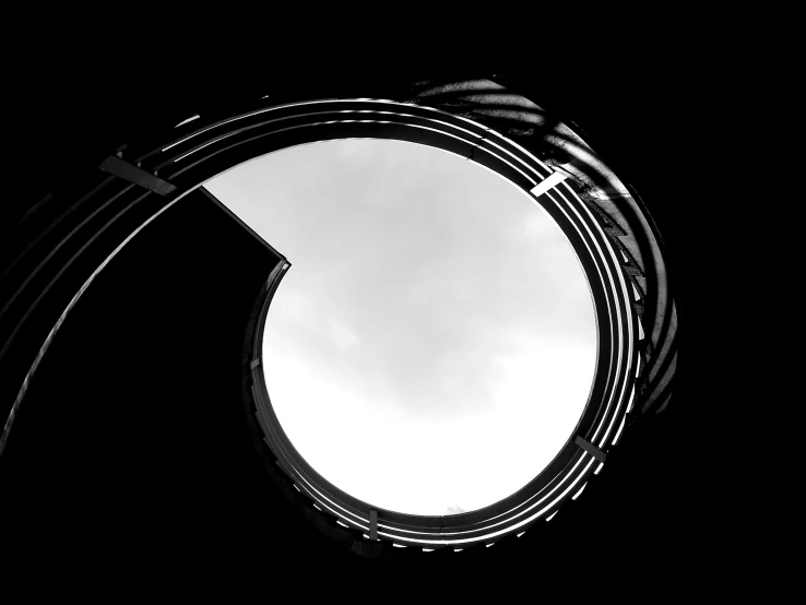 a black and white photo of a circular window, a black and white photo, inspired by László Moholy-Nagy, unsplash, abstract illusionism, stairway to heaven, ffffound, swirly tubes, harp