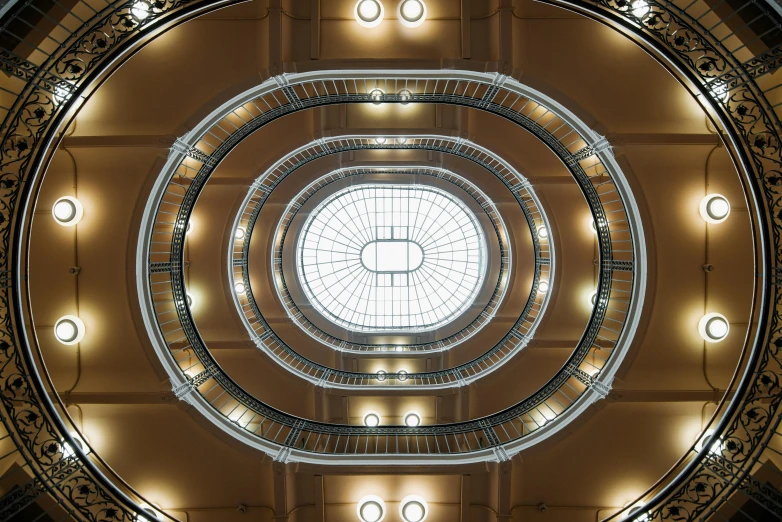 a spiral staircase in a building with a skylight, inspired by János Nagy Balogh, unsplash contest winner, art nouveau, symmetric lights, 2 5 6 x 2 5 6 pixels, dome, ochre