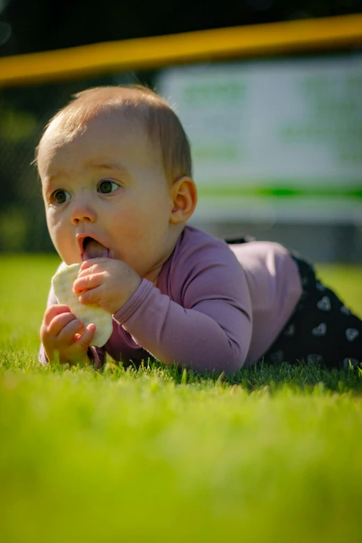 a baby laying on top of a lush green field, a picture, by Sven Erixson, shutterstock contest winner, eating ice cream, square nose, she has beautiful bone structure, 15081959 21121991 01012000 4k