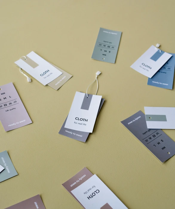a bunch of tags sitting on top of a table, international typographic style, muted colour palette, product introduction photo, labels, glen