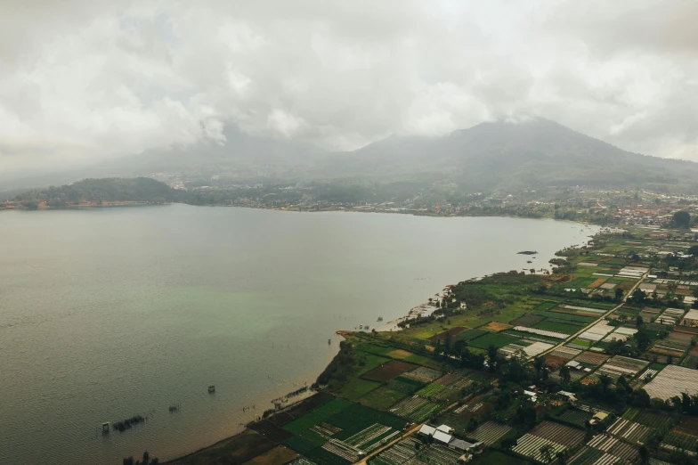 a large body of water with a mountain in the background, by Daniel Lieske, pexels contest winner, mingei, bird's - eye view, day after raining, tankoban, hd footage