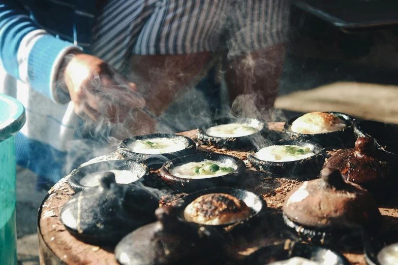 a close up of a person cooking food on a grill, a photo, by Lee Loughridge, trending on unsplash, renaissance, moroccan tea set, steamed buns, inside an arabian market bazaar, instagram story