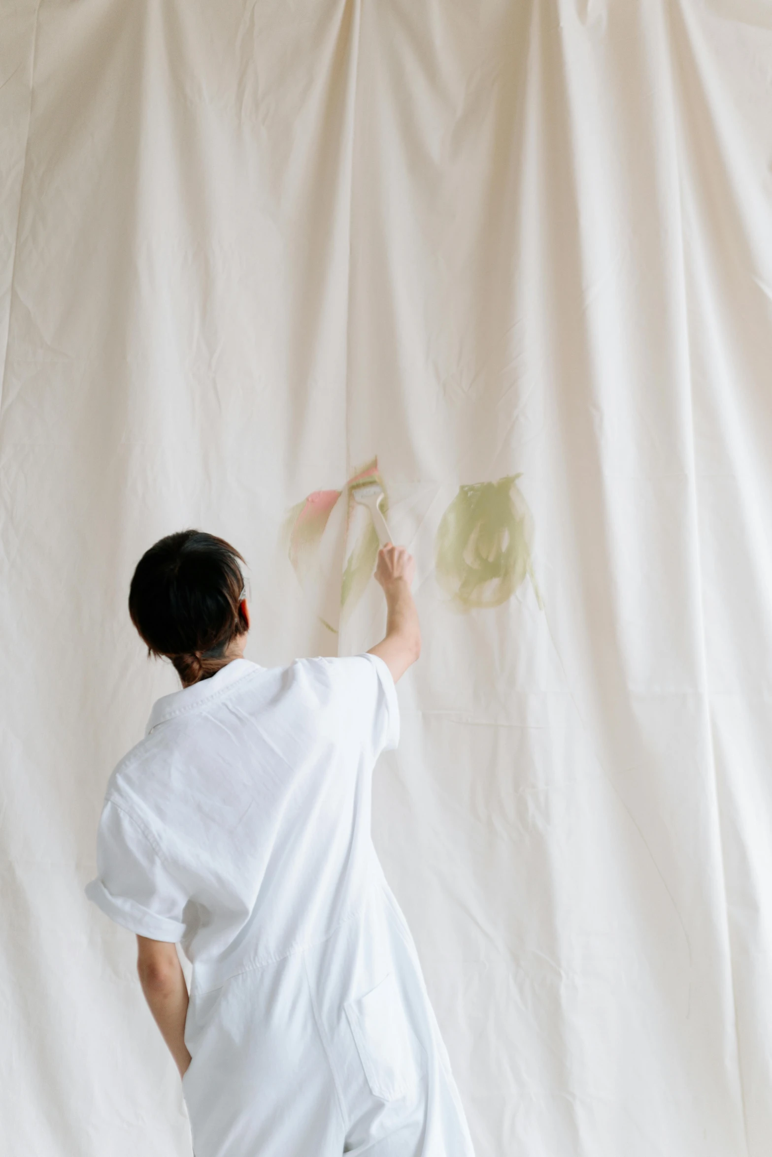 a man that is standing in front of a white curtain, a minimalist painting, inspired by Shōzō Shimamoto, trending on unsplash, action painting, leaves and simple cloth, girl in studio, making of, sana takeda