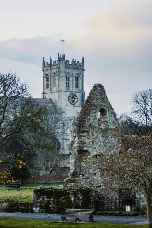 a stone building with a clock tower in the background, by Kev Walker, romanesque, destroyed monastery, warwick saint, with dark trees in foreground, amber