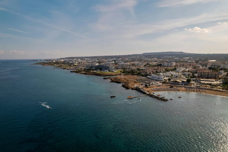 a large body of water next to a beach, pexels contest winner, les nabis, helicopter footage over city, cyprus, wide views, cinematic image