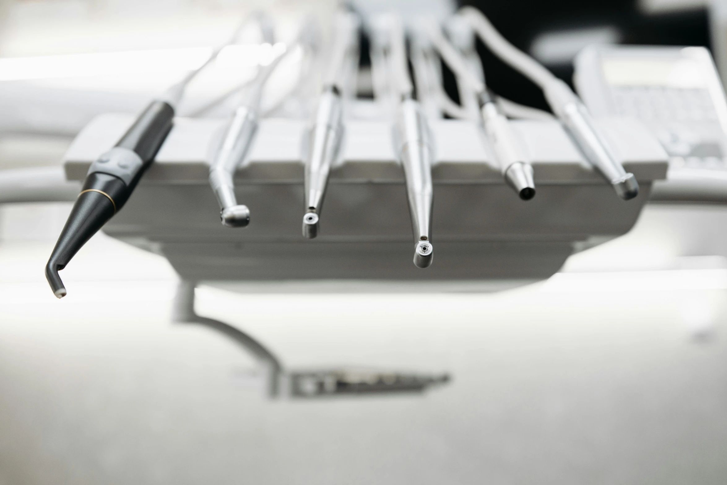 a bunch of dental tools sitting on top of a table, a picture, by Daniel Gelon, unsplash, with big chrome tubes, bottom body close up, lower quality, surgery table