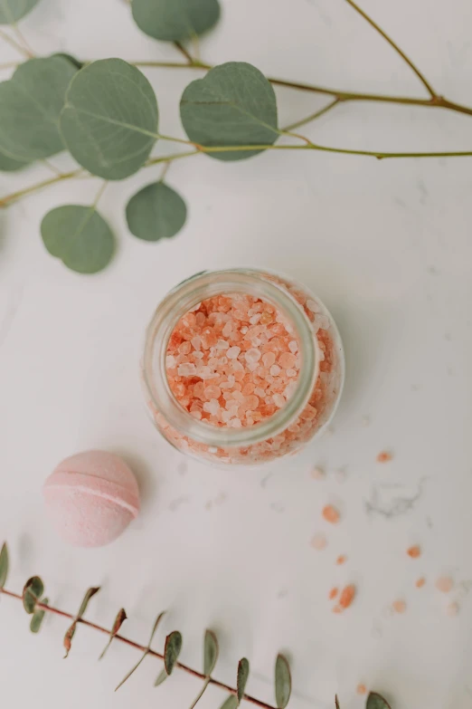 a jar of bath salts sitting on top of a table, a picture, pexels, macaron, peach embellishment, shot from above, pink mist