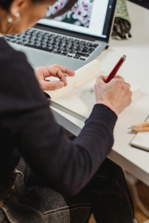 a woman sitting at a desk writing on a piece of paper, a drawing, pexels contest winner, sitting at his desk, 🦑 design, holding notebook, red ballpoint pen