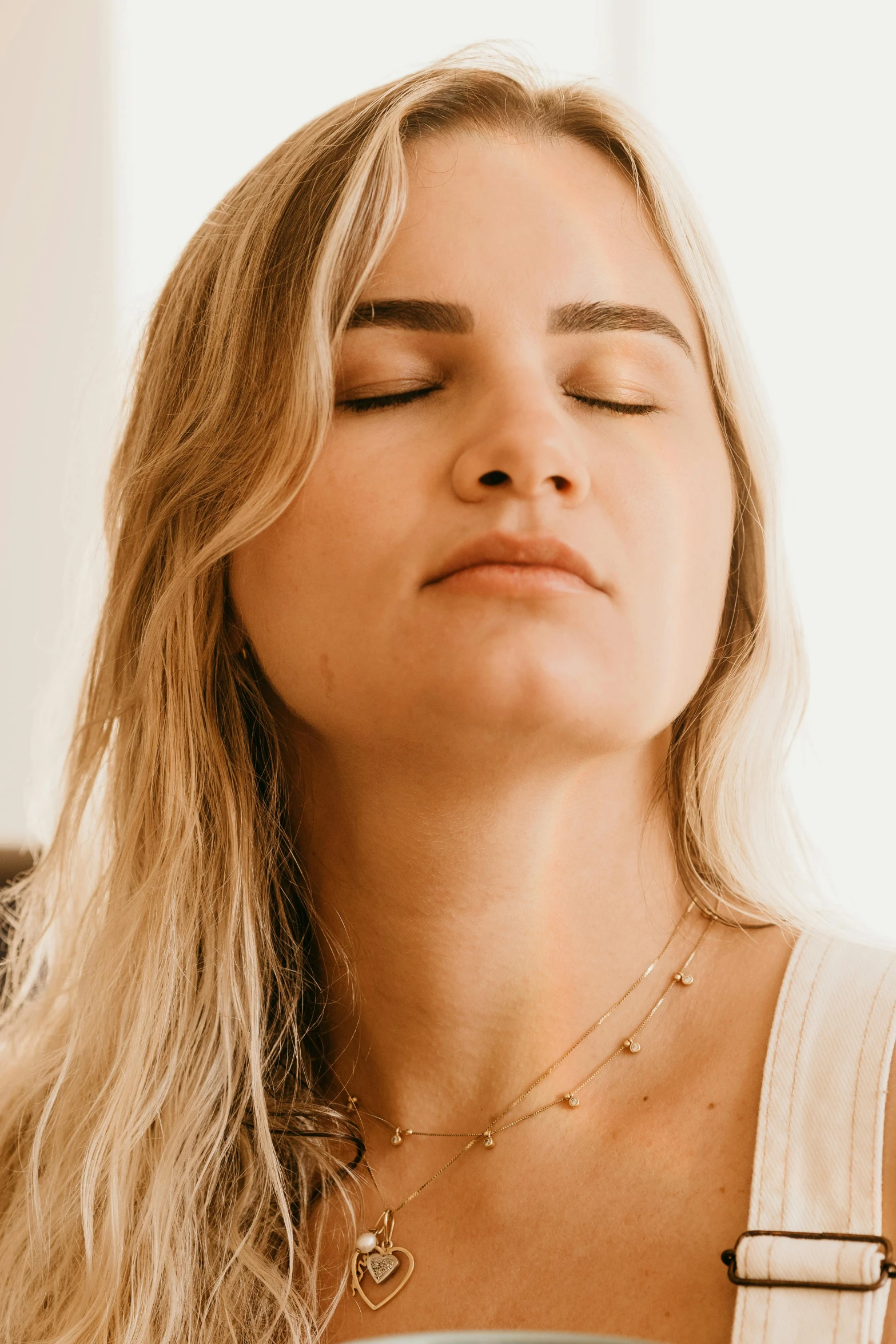 a woman with her eyes closed holding a cup of coffee, inspired by Elsa Bleda, trending on pexels, light and space, neck zoomed in from lips down, chakra diagram face, blonde, praying meditating