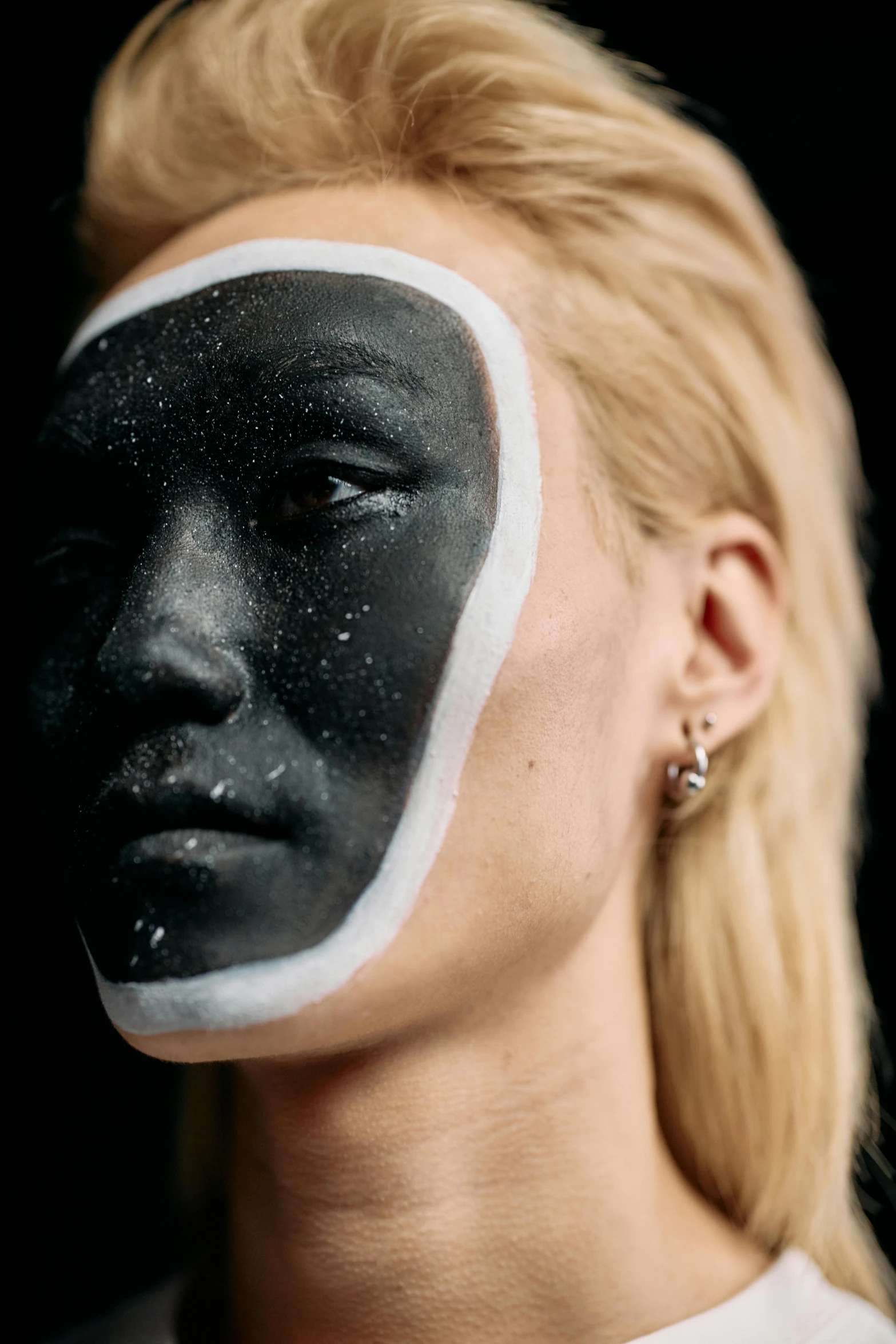 a woman with black and white paint on her face, an album cover, trending on pexels, cosmic girl, with a white complexion, synthetic bio skin, face photo