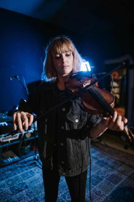 a woman playing a violin in a dark room, a portrait, unsplash, bauhaus, square, beth cavener, overlooking, sonic youth