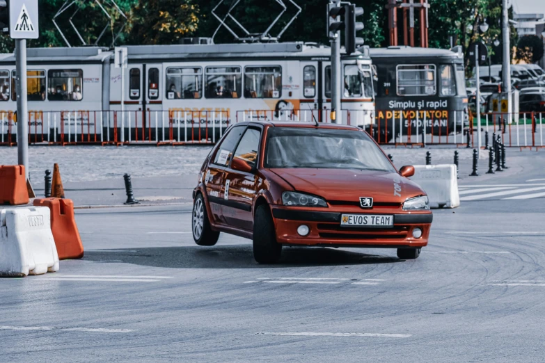 a red car driving down a street next to a train, by Adam Marczyński, pexels contest winner, on a street race track, glass and metal : : peugot onyx, drifting, renault