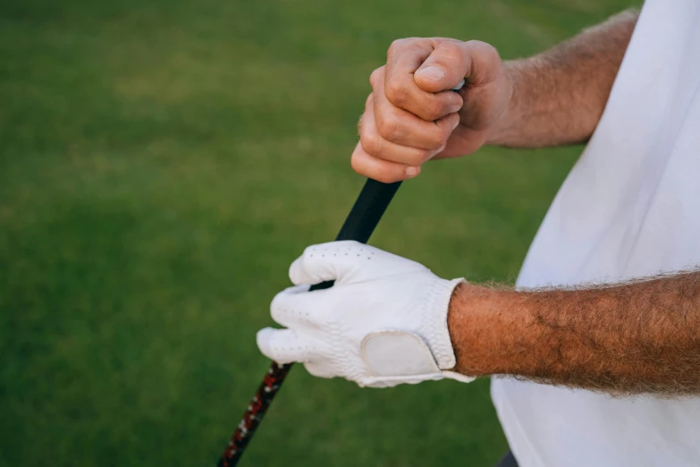 a close up of a person holding a golf club, phantom grip, small, left hand propping up the head, hands down