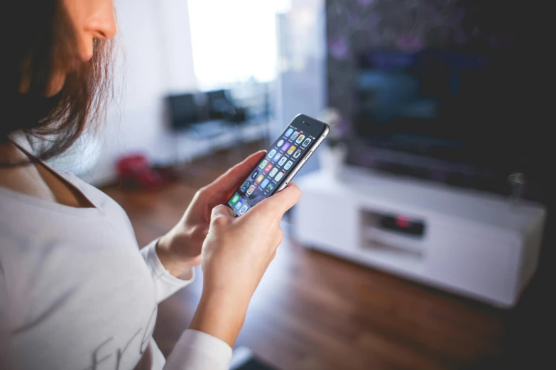 a woman holding a smart phone in front of a tv, pexels, square, older male, with apple, multicoloured