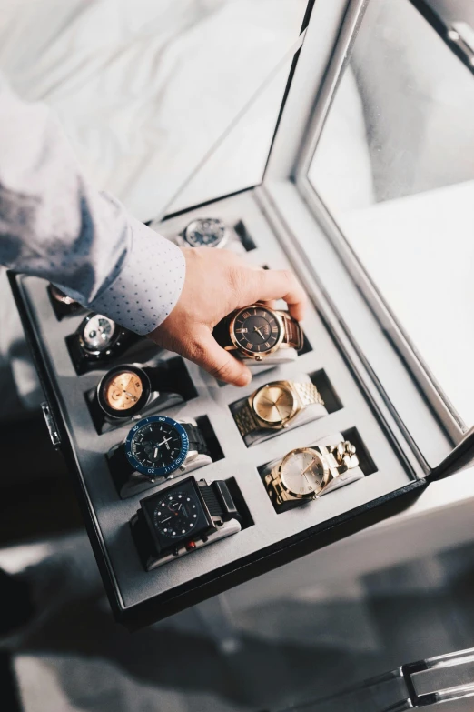 a close up of a person holding a watch in a case, product display, organized, multiple stories, or black