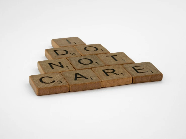 a scrabble with the words don't care written on it, by Joel Shapiro, conceptual art, skincare, ( ( ( ( 3 d render ) ) ) ), a wooden, scarfolk
