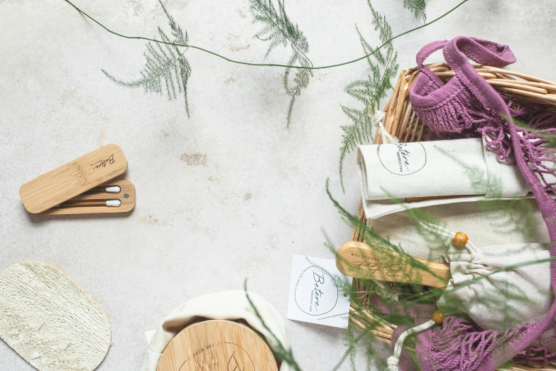 a basket filled with items sitting on top of a table, inspired by Eden Box, unsplash, private press, detail shot, fern, pair of keycards on table, made of bamboo