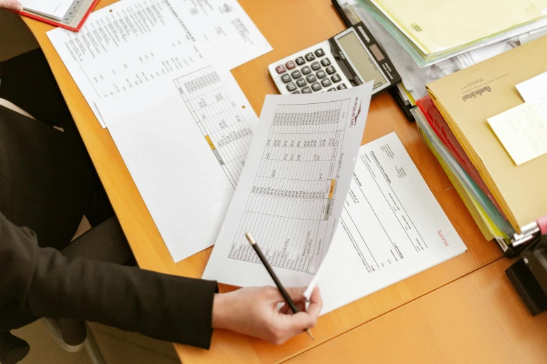 a person sitting at a desk with papers and a calculator, private press, expert design, thumbnail, inspect in inventory image, royal commission