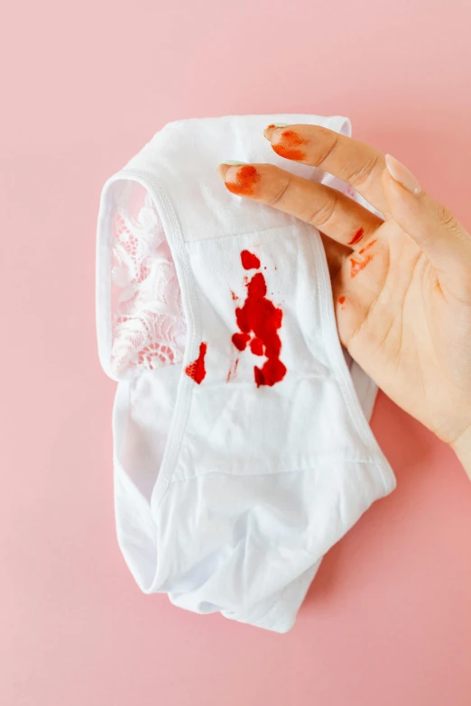 a woman's hand holding a cloth with blood on it, by Julia Pishtar, cute panties, made of lab tissue, white clothes, oops