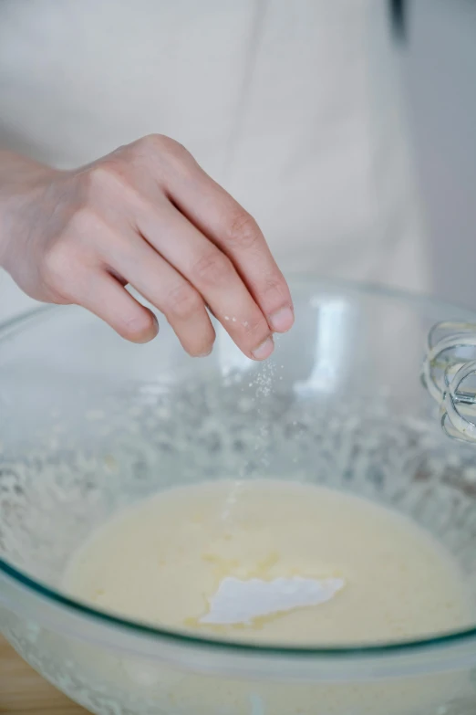 a person using a whisk to whisk eggs in a bowl, inspired by Yukimasa Ida, glassy fracture, square, promo image, silver，ivory