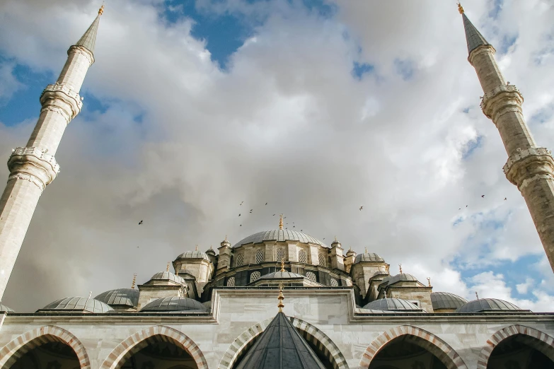 a large white building with a blue sky in the background, a marble sculpture, by Ismail Acar, pexels contest winner, hurufiyya, black domes and spires, turkish and russian, view from ground, brown