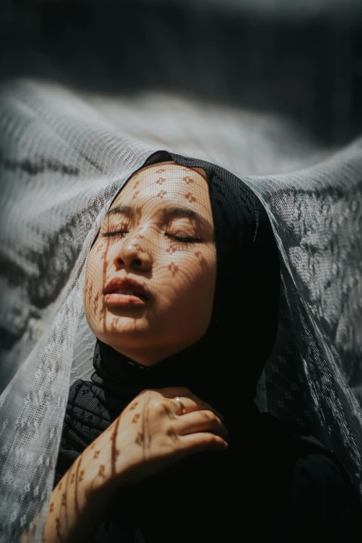 a woman with her eyes closed wearing a veil, by Basuki Abdullah, unsplash contest winner, hyperrealism, covered with black goo, dead skin, instagram post, teenage girl