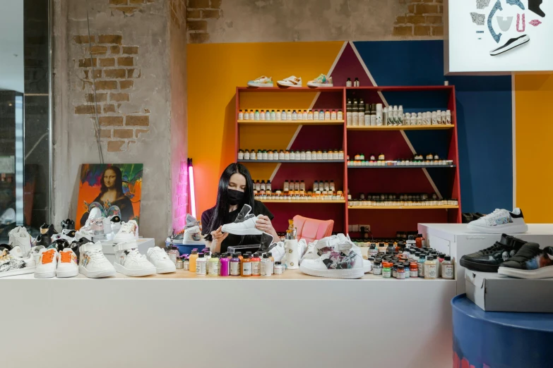 a woman sitting at a counter in a shoe store, unsplash, process art, she is in the potions workshop, okuda, toothpaste refinery, white wall coloured workshop