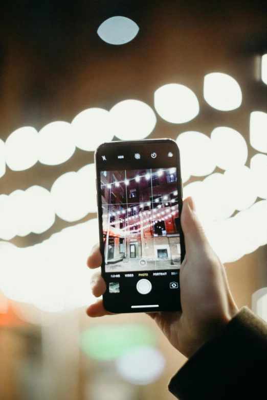 a person taking a picture with their cell phone, a picture, by Dan Content, trending on pexels, dazzling lights, centered in portrait, slightly pixelated, iphone screenshot