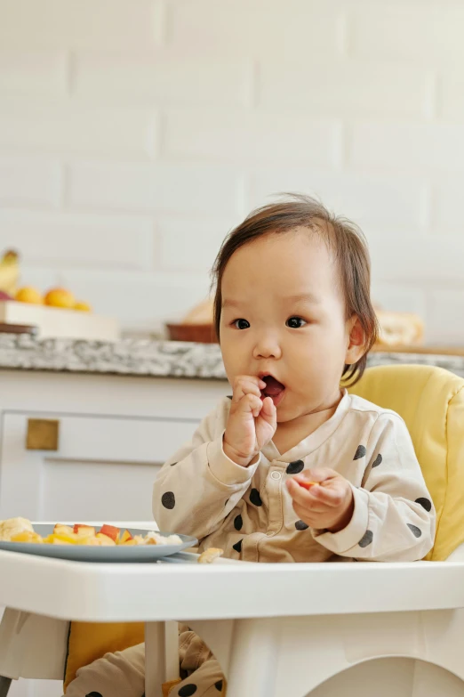 a baby sitting in a high chair eating food, unsplash, yellow, korean, square, small chin