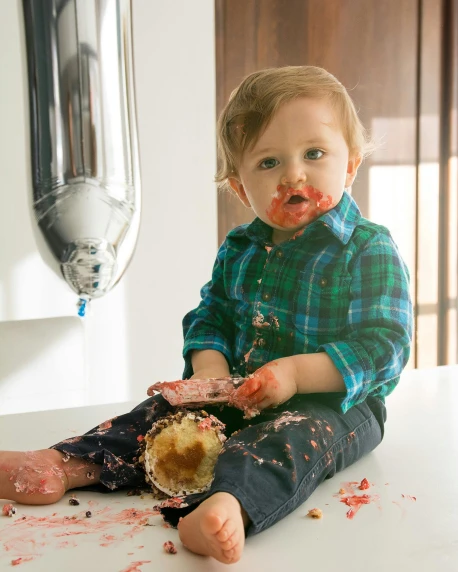 a little boy sitting on top of a counter covered in food, a photorealistic painting, by Arabella Rankin, unsplash, red birthmark, splattered tar, 15081959 21121991 01012000 4k, eating cakes