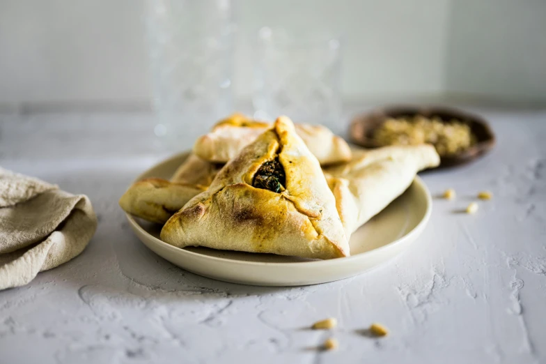 a close up of a plate of food on a table, by Julia Pishtar, hurufiyya, triangles, pastry, israel, background image