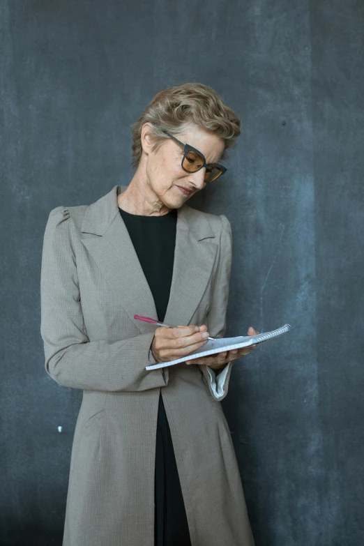 a woman in a business suit writing on a clipboard, pexels contest winner, visual art, professor clothes, grey, profile picture, older woman