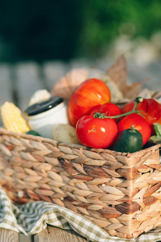 a basket filled with tomatoes sitting on top of a wooden table, offering a plate of food, snacks, veggies, profile image