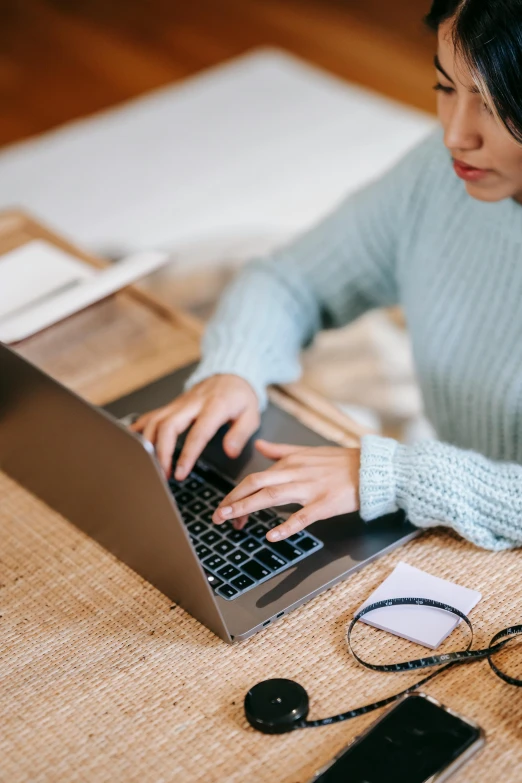 a woman sitting at a table using a laptop computer, trending on pexels, sustainable materials, avatar image, bottom angle, 1 2 9 7