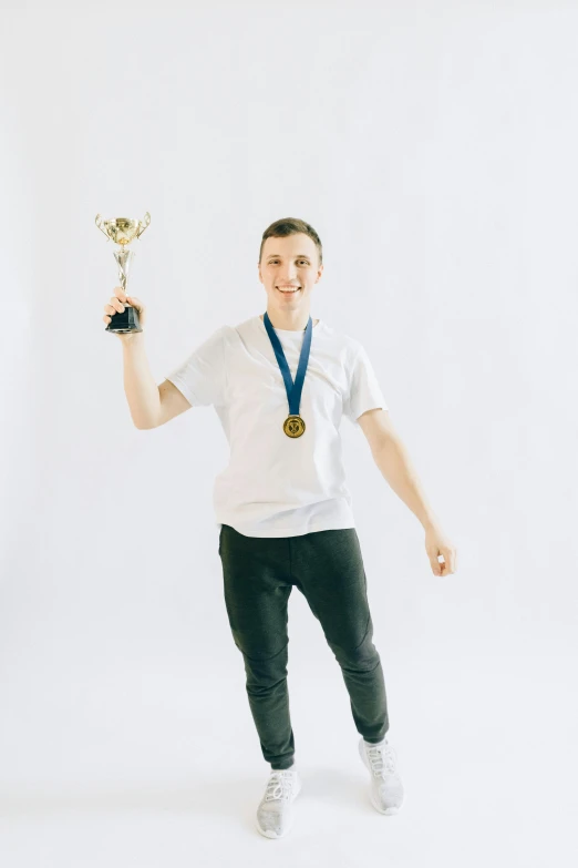 a man in a white shirt holding a trophy, by Adam Marczyński, pexels contest winner, in front of white back drop, avatar image, around 1 9 years old, linus from linustechtips