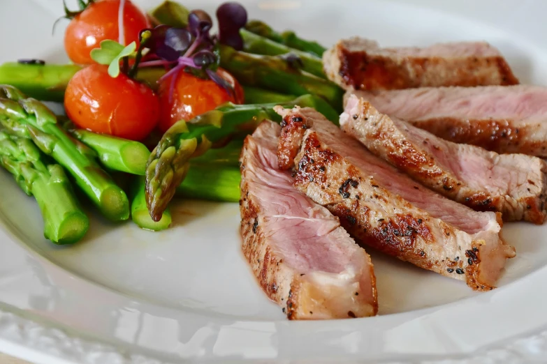 a white plate topped with meat and vegetables, asparagus, premium quality, trending photo, thumbnail