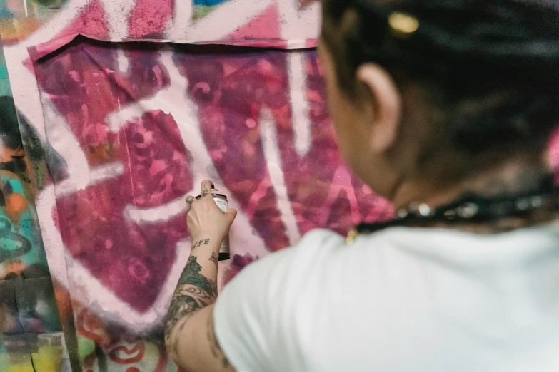 a woman is painting graffiti on a wall, an airbrush painting, by Andrée Ruellan, pexels contest winner, graffiti, lil peep, 144x144 canvas, cloth banners, james jean and jenny saville