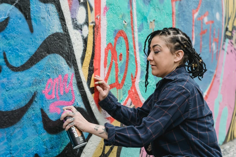 a woman spray painting graffiti on a wall, by artist, pexels contest winner, mac miller, 40 years old women, thumbnail, lgbtq