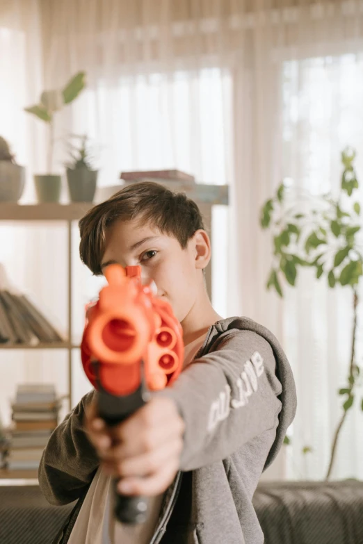 a boy holding a toy gun in a living room, pexels contest winner, headshot profile picture, nerf or nothing, hero action pose, instagram post