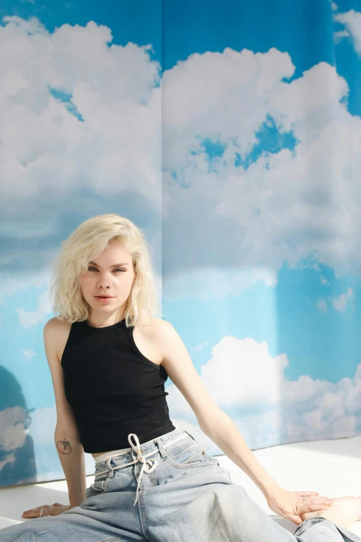 a woman sitting on top of a bed in a room, an album cover, inspired by Elsa Bleda, trending on unsplash, white cloud hair, blue sky, crop top, with pale skin