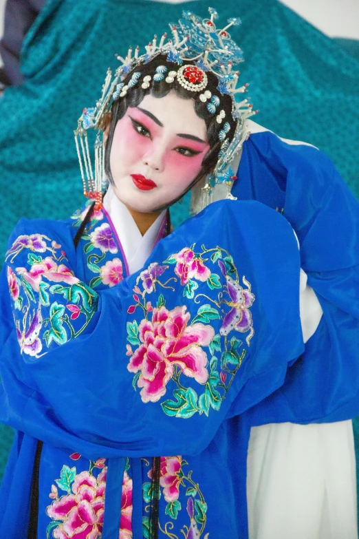 a woman in a blue dress posing for a picture, an album cover, inspired by Jin Nong, pexels contest winner, cloisonnism, high quality theatre costume, embroidered robes, closeup of arms, square