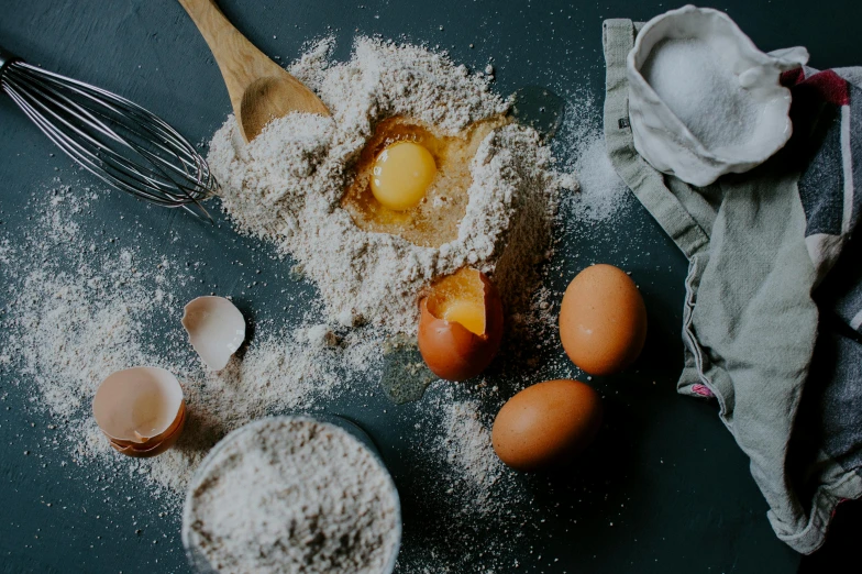 eggs, flour, and a whisk on a table, pexels contest winner, thumbnail, fan favorite, dark bacgkground, edible crypto