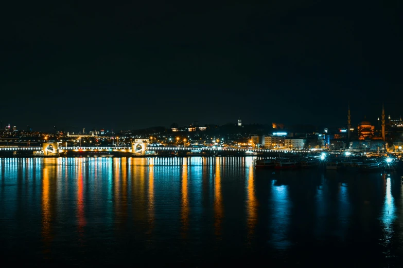 a large body of water next to a city at night, by Thomas Häfner, pexels contest winner, plain background, port scene background, teal lights, panoramic