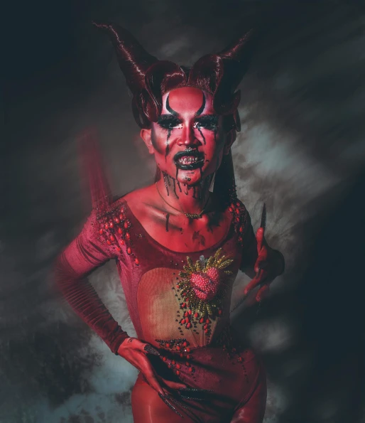 a woman in a devil costume posing for a picture, an album cover, by Adam Marczyński, pexels contest winner, transgressive art, bodypaint, horned, high resolution print :1 red, sinister complexion