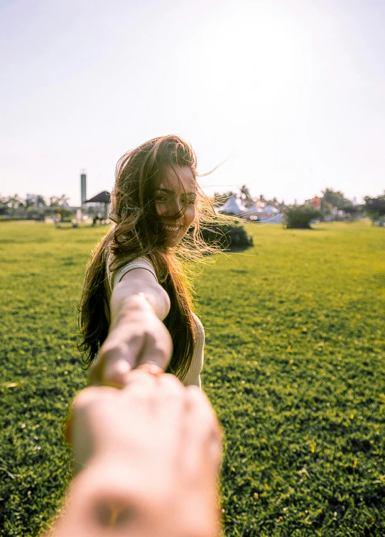 a woman holding a man's hand in a field, a picture, happening, taken on go pro hero8, beauty, at a park, instagram photo