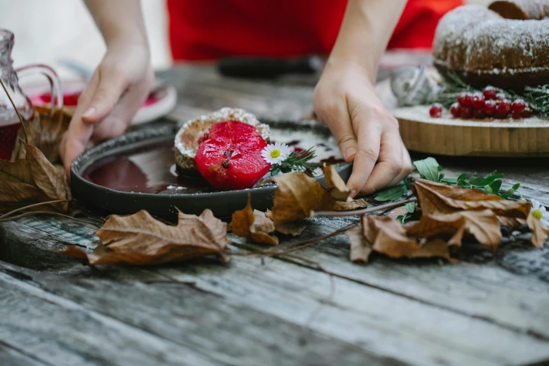 a close up of a plate of food on a table, by Julia Pishtar, pexels contest winner, process art, ritual in a forest, wearing a red gilet, baking artwork, made out of clay