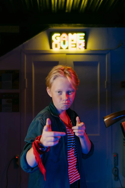a woman standing in front of a neon sign, pexels contest winner, blond boy, giving a thumbs up to the camera, game, nick park