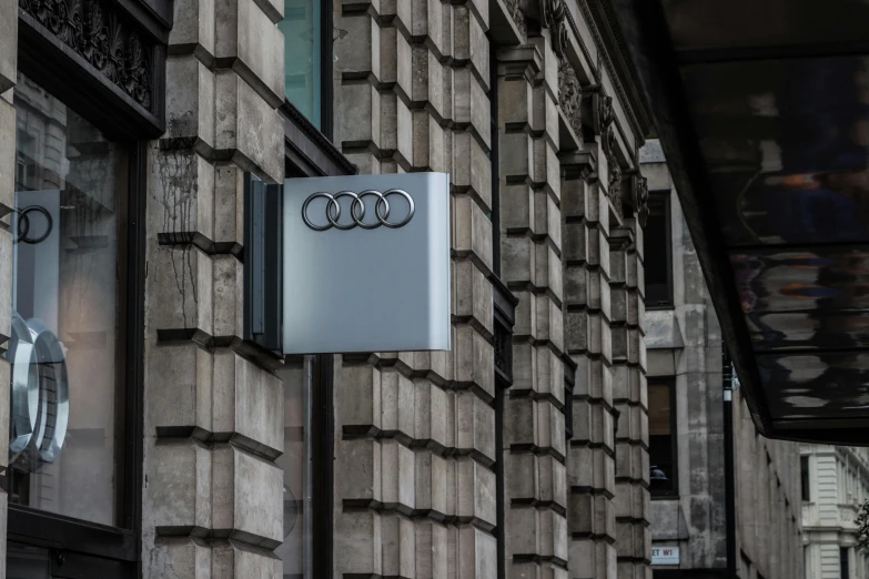 a sign that is on the side of a building, by Tobias Stimmer, unsplash contest winner, bauhaus, 2 0 2 1 formula 1 audi car, glasgow, architecture carved for a titan, 🚿🗝📝