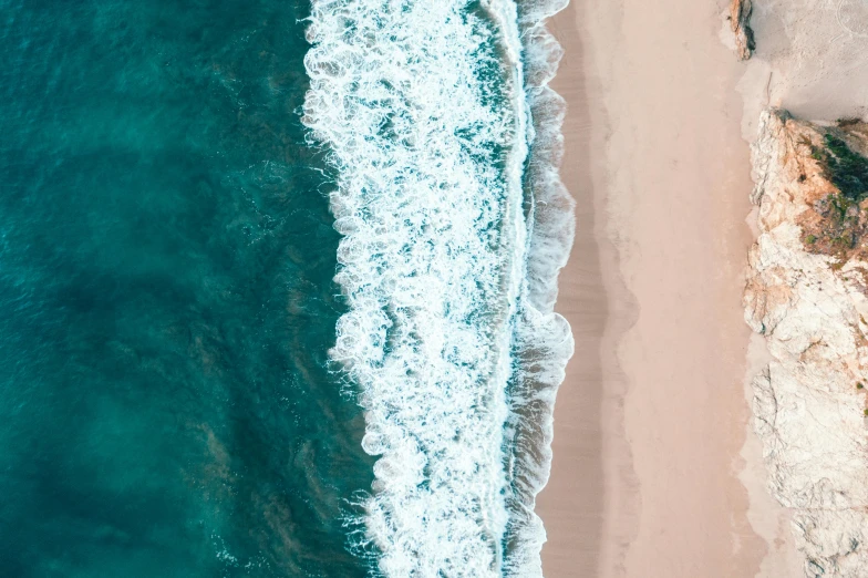 a large body of water next to a sandy beach, by Robbie Trevino, pexels contest winner, close-up from above, ocean spray, unsplash photo contest winner, paper